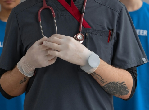 A doctor leading with volunteers in the background