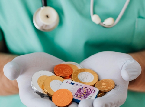 The doctor is holding money in gloved hands.